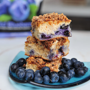 Devotion Nutrition Wild Blueberry protein powder package with a shake and muffins on a light gray background