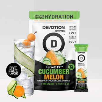 A Devotion Nutrition HydroFLEX Cucumber Melon flavored water and smoothie enhancer pouch shown with a single stick pack and a glass of water with cucumber and orange slices on a light gray background.