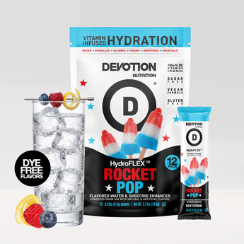 A Devotion Nutrition HydroFlex Rocket Pop flavored drink mix pouch shown with a single stick pack and a glass of iced water with fruit garnish on a light gray background.