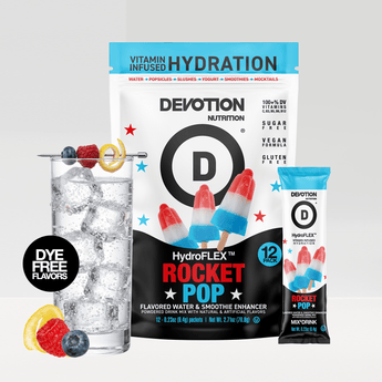 A Devotion Nutrition HydroFlex Rocket Pop flavored drink mix pouch shown with a single stick pack and a glass of iced water with fruit garnish on a light gray background.