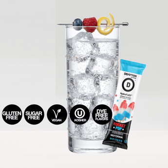 A Devotion Nutrition HydroFlex Rocket Pop flavored drink mix pouch shown with a single stick pack and a glass of iced water with fruit garnish on a light gray background.