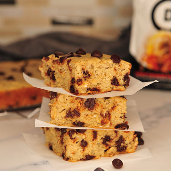 Devotion Nutrition Salted Caramel Cone protein powder package with a milkshake and cookies on a light gray background