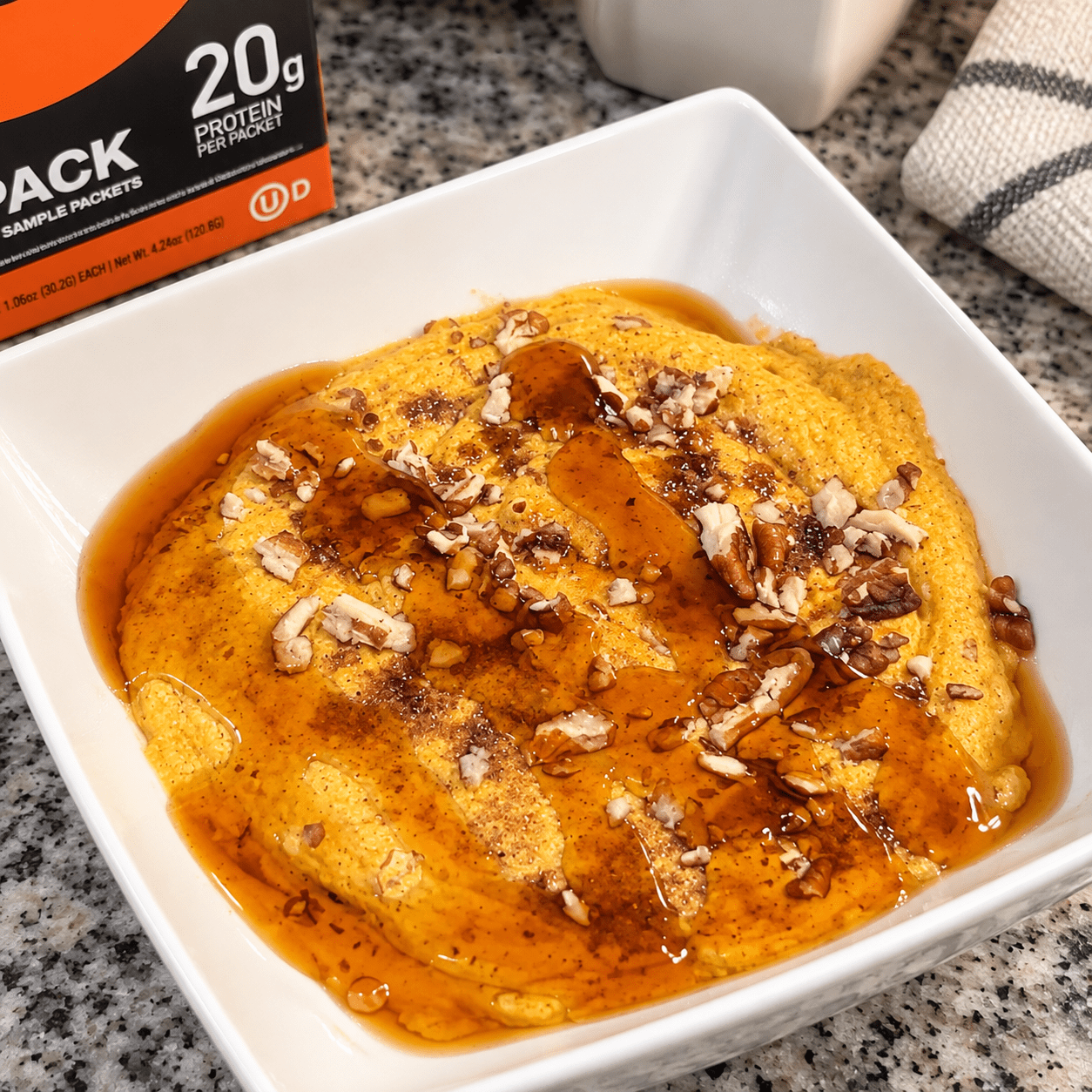  Devotion, Nutrition, pumpkin protein, pancake bowl with syrup and pecans on top made with a sample of the Sinful cinnamon protein from Devotion Nutrition's variety pac