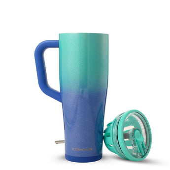 A tall handled tumbler with a teal-to-blue gradient body  a blue handle  and a teal straw lid. The front features a large circular 'D' logo with the word 'DEVOTION' and smaller 'NUTRITION' text below  plus 'ICE shAKER' near the bottom.