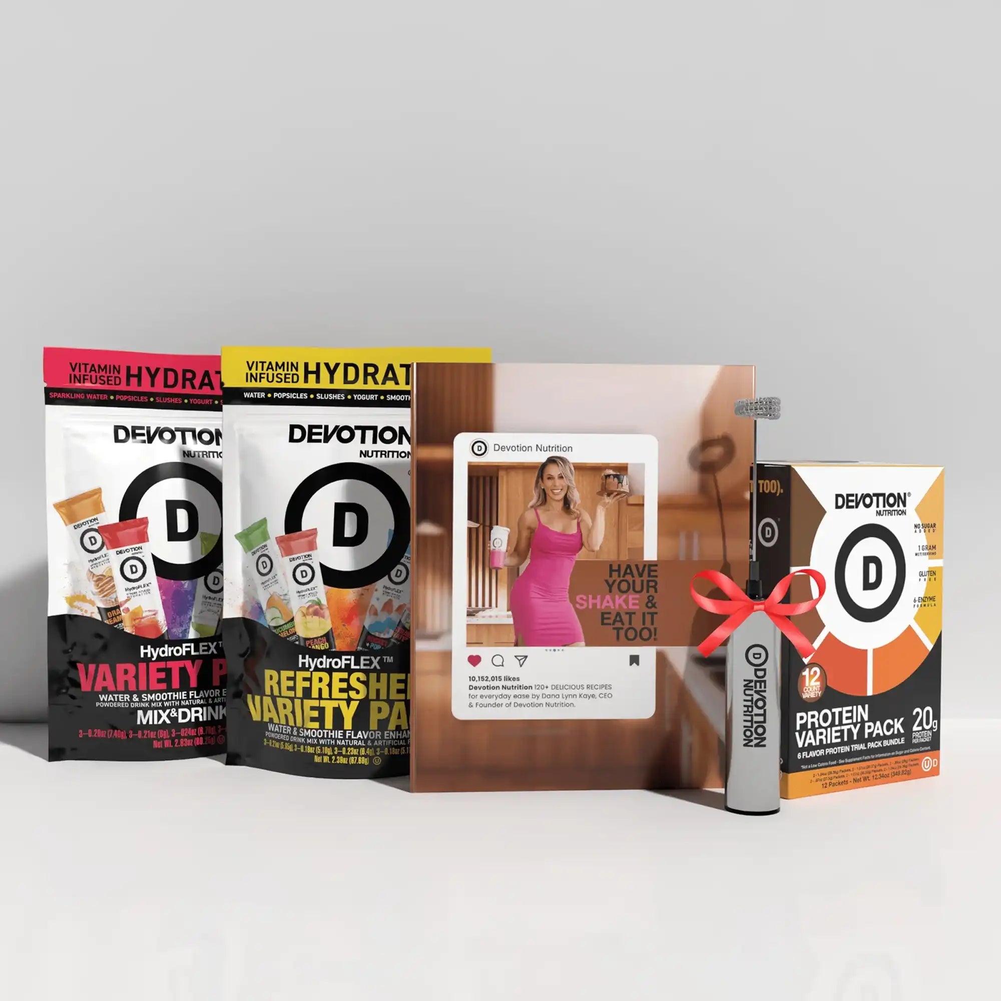 Collection of Devotion Nutrition products including protein packs and a magazine on a white surface.