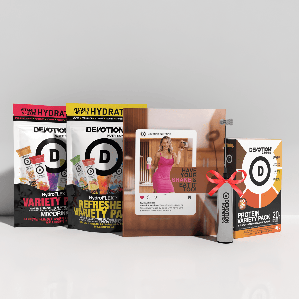 Collection of Devotion Nutrition products including protein packs and a magazine on a white background