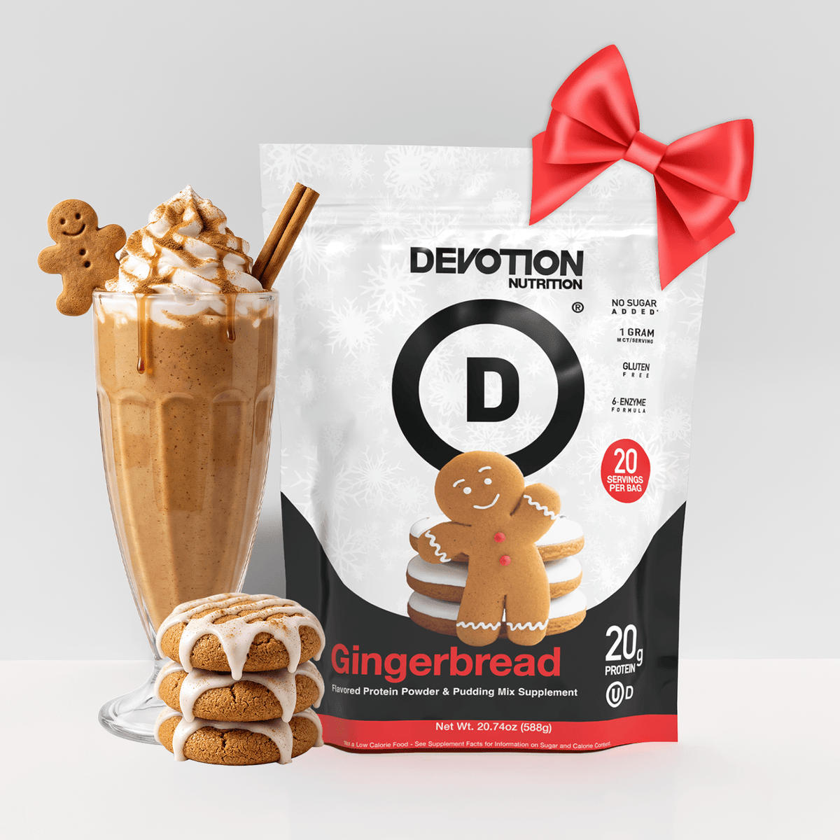 A bag of Devotion Nutrition Gingerbread flavored protein powder and pudding mix is shown with a decorated milkshake, two gingerbread cookies