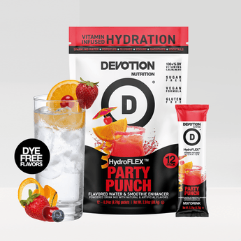 A Devotion Nutrition HydroFLEX Party Punch flavored drink mix pouch shown with a single stick pack and a glass of iced drink garnished with fruit  on a light gray background.