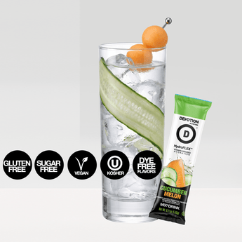A Devotion Nutrition HydroFLEX Cucumber Melon flavored water and smoothie enhancer pouch shown with a single stick pack and a glass of water with cucumber and orange slices  on a light gray background.